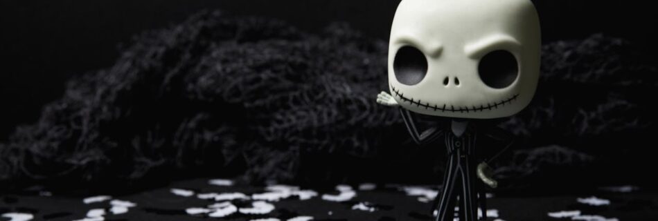 A creepy toy figure on a dark background adorned with eerie white shapes, ideal for Halloween themes.